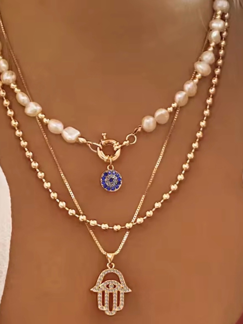Multi-Layered Gold Pearl Hamsa Necklace with Blue Charm